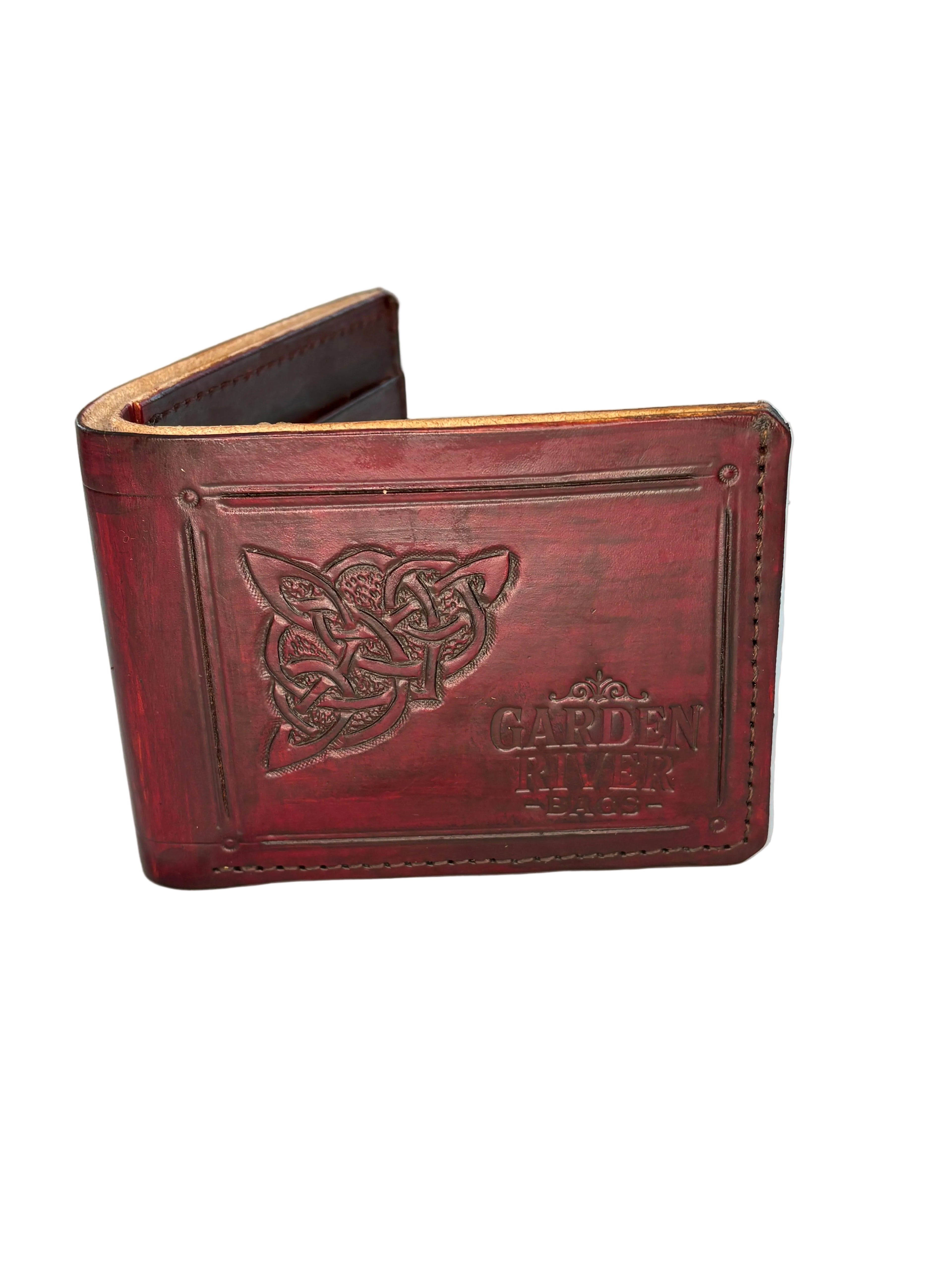 Brown leather bi-fold wallet with hand tooled design on a white surface